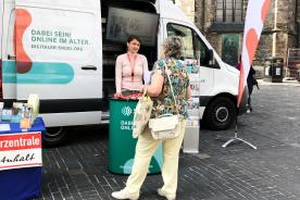 Marktplatz Halle an der Saale mit Infomobil. Personen stehen davor und unterhalten sich