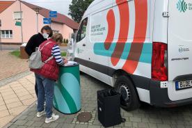 Unterhaltung zweier Personen vor dem Infomobil der Digitalen Engel am Marktplatz in Kloster-Lehnin