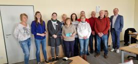 Ein Gruppenbild der Veranstaltung mit den Teilnehmenden, der Geschäftsführerin Frau Heydel und dem Bürgermeister Herr Hetzel. Herr Hetzel steht auf der rechten Seite. Frau Heydel zwischen den Teilnehmenden.