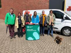 Sechs Personen und ein Hund stehen am Info-Mobil und lächeln in die Kamera. In der Mitte steht Referentin Petra. Links Diakon Frank Peters und Pastorin Katharina Riemer und rechts von ihr Diakonin Silke Langer. Der Hund heißt Josef.