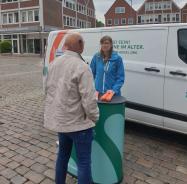 Wilfried steht mit Petra am Info-Stand vor dem Info-Mobil.