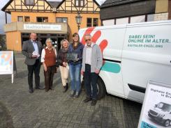 Am Info-Mobil stehen Bürgermeister Breithecker mit zwei Seniorinnen. Rechts daneben steht Petra mit Herrn Gutzeit von der Stadtbücherei.