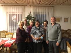 Vier Teilnehmerinnen und zwei Teilnehmer stehen vor einem Tannenbaum im Ortwiger Gemeindezentrum und lächeln in die Kamera.