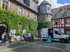 Mehrere Personen stehen an Infoständen im Hof vor dem Museumsgebäude 