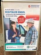 Ein Foto von einem Aufsteller mit Werbung für den Besuch des Digitalen Engel in Norderstedt.