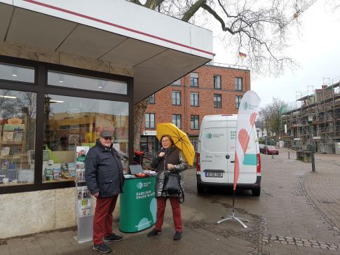 Eine Besucherin steht am Infostand und unterhält sich mit Herrn Winner