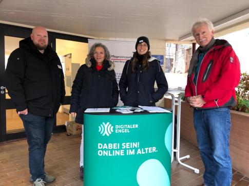 Petra steht mit zwei Kooperationspartner und dem Vorsitzenden der Stadtvertetung am Info-Stand.